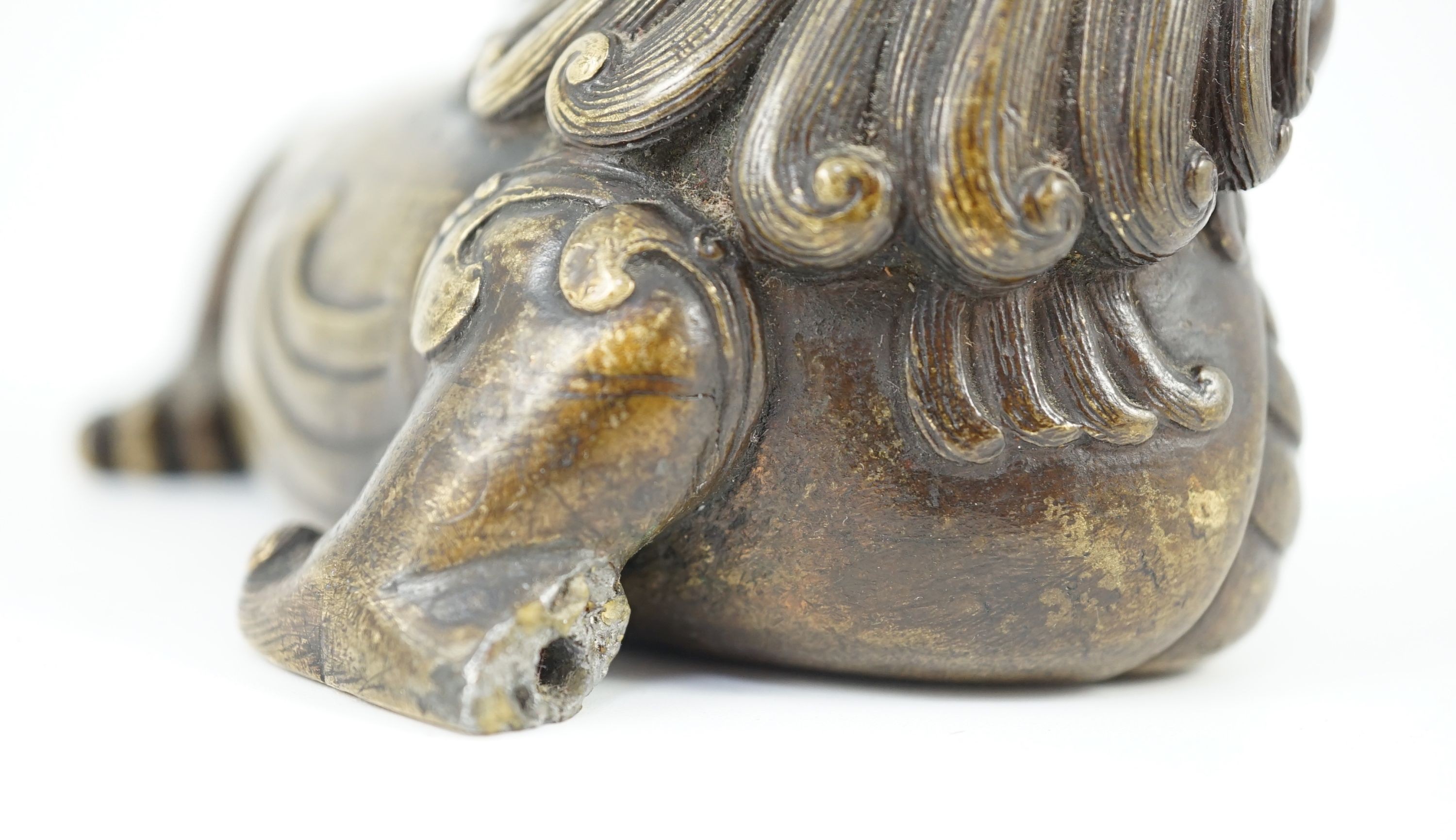 A finely cast Chinese bronze lion-dog and cub scroll weight, 17th/18th century, 14cm long, one foot and a cub lacking